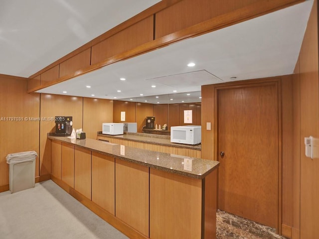 19667 Turnberry Way Unit 16Gr, Aventura, FL 33180 - kitchen featuring white microwave, a peninsula, stone countertops, brown cabinetry, and recessed lighting
