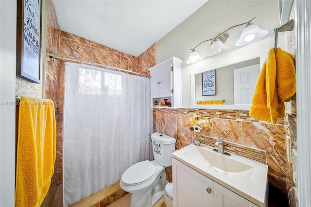 full bathroom featuring toilet, a shower with curtain, tile walls, backsplash, and vanity
