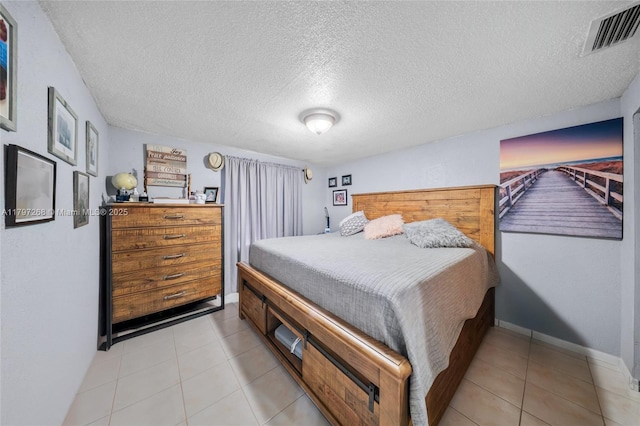 bedroom featuring a textured ceiling, visible vents, and baseboards