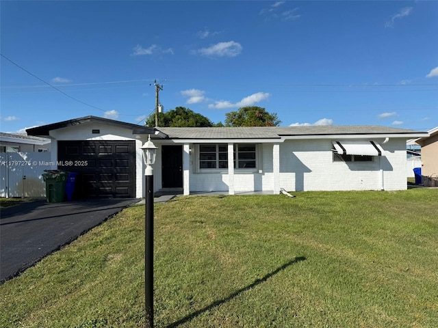 ranch-style home featuring an attached garage, a front yard, driveway, and brick siding