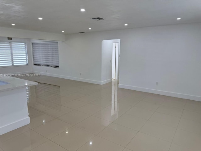 unfurnished room with baseboards, recessed lighting, and light tile patterned floors