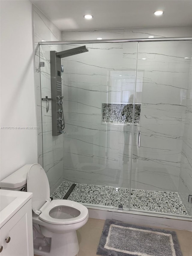 full bathroom featuring toilet, a marble finish shower, recessed lighting, and vanity