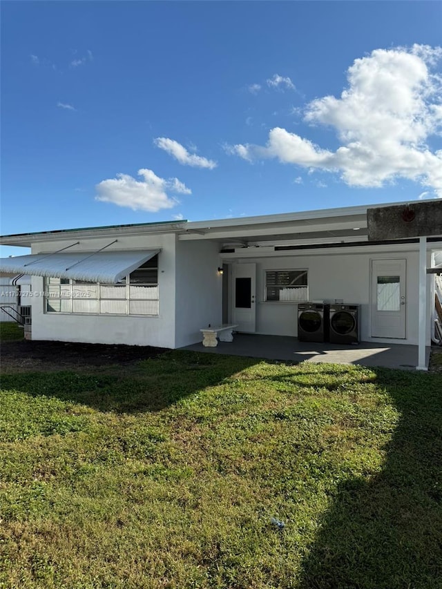 back of property with a lawn, a cooling unit, and stucco siding