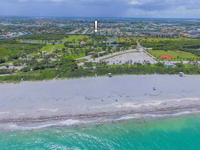 birds eye view of property featuring a beach view and a water view