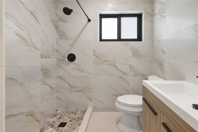 full bath featuring vanity, toilet, and a tile shower