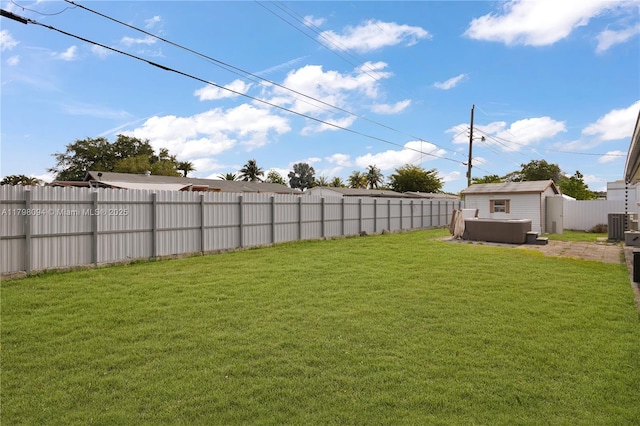 view of yard with a fenced backyard, a storage unit, and an outbuilding