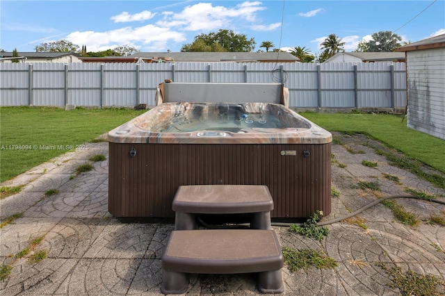 view of patio / terrace with a hot tub and fence