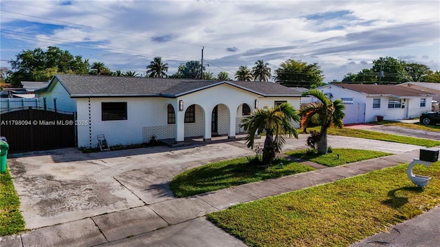 view of front of home featuring curved driveway, fence, a gate, and a porch