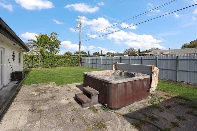 view of yard with a hot tub, a fenced backyard, and a patio