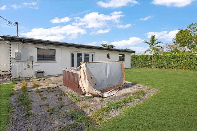 rear view of property featuring a yard and central AC unit