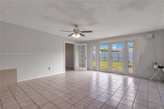 unfurnished room featuring baseboards, tile patterned flooring, ceiling fan, and a textured ceiling