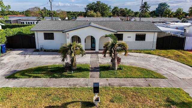 ranch-style home with a gate, covered porch, fence, and curved driveway