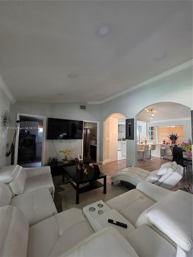 living room with crown molding, visible vents, washer / clothes dryer, and arched walkways