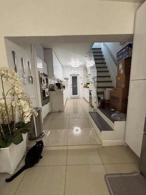 224 E 42nd St, Hialeah, FL 33013 - hallway with light tile patterned floors and stairway