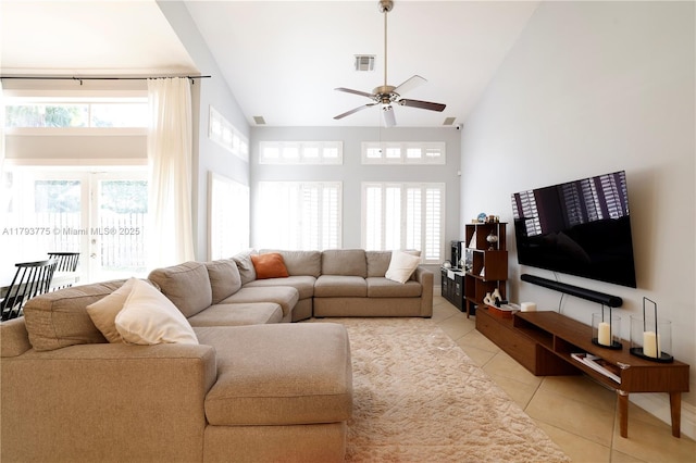 living area featuring a ceiling fan, visible vents, light tile patterned flooring, and high vaulted ceiling