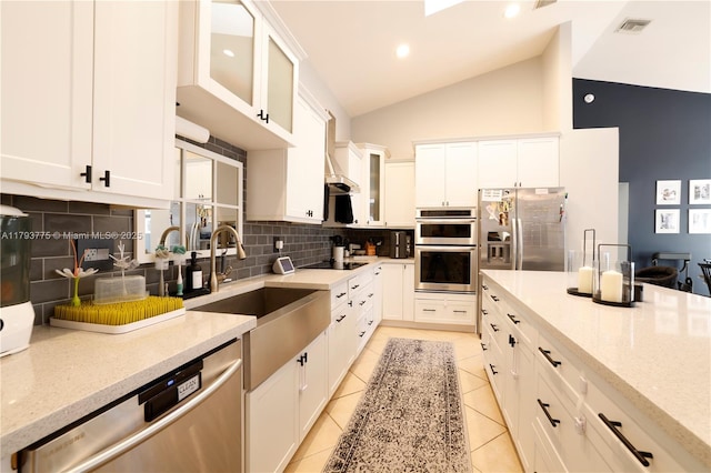 kitchen with light tile patterned floors, a sink, white cabinetry, backsplash, and appliances with stainless steel finishes