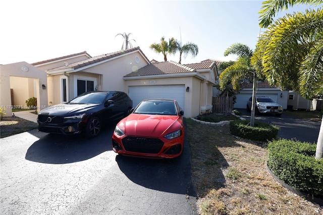 view of front of house with a garage, stucco siding, a tiled roof, and driveway