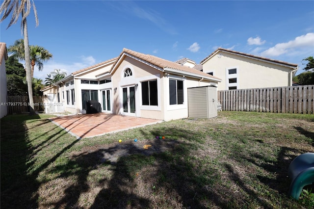 back of property with a yard, a patio, stucco siding, and fence private yard