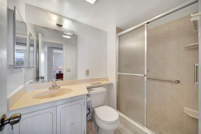bathroom with vanity, toilet, tile patterned flooring, and a shower stall