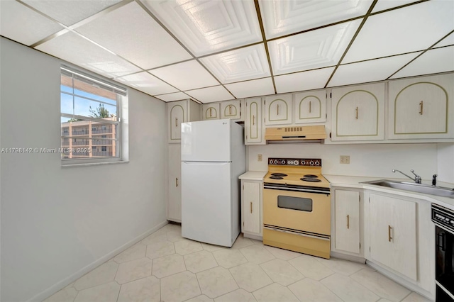 kitchen featuring a sink, baseboards, white appliances, under cabinet range hood, and light countertops