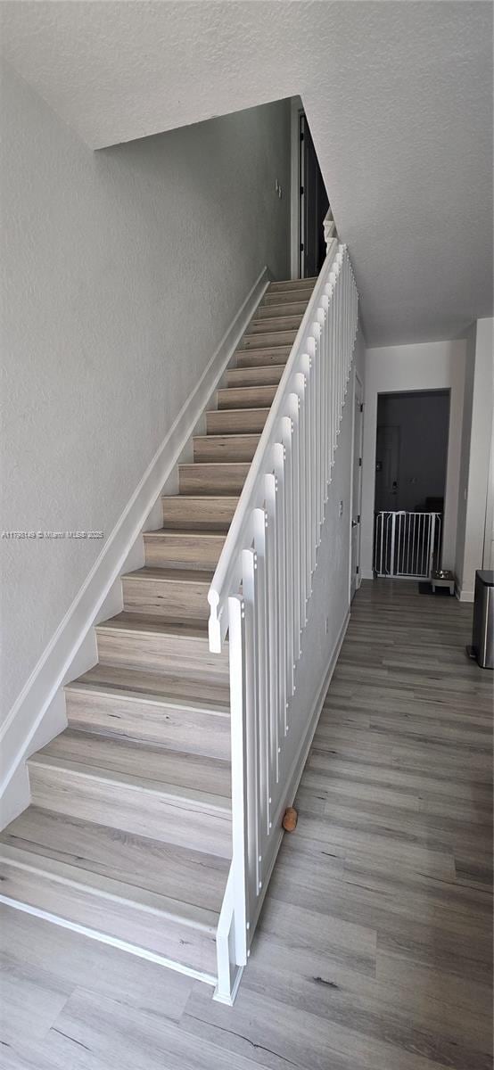 531 SW 147th Ave Unit 2-4, Pembroke Pines, FL 33027 - stairway with a textured ceiling, wood finished floors, baseboards, and a textured wall