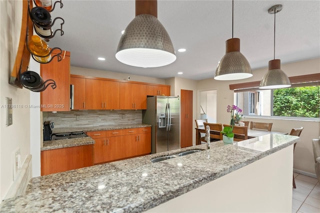 631 NW 205th Ave, Pembroke Pines, FL 33029 - kitchen with a sink, brown cabinetry, tasteful backsplash, stainless steel fridge, and electric stove