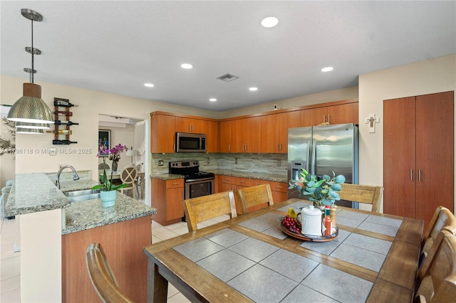 631 NW 205th Ave, Pembroke Pines, FL 33029 - kitchen with a sink, a peninsula, brown cabinets, and appliances with stainless steel finishes