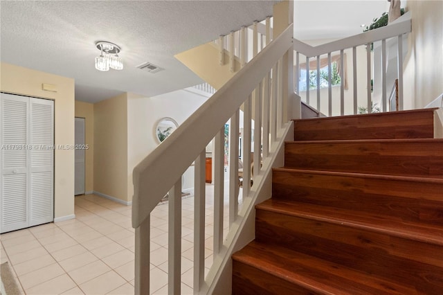 631 NW 205th Ave, Pembroke Pines, FL 33029 - stairs featuring a textured ceiling, baseboards, visible vents, tile patterned floors, and a chandelier