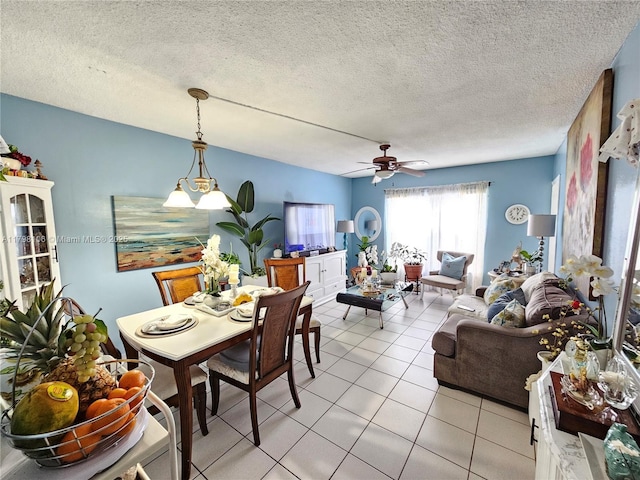 dining space featuring a ceiling fan, light tile patterned flooring, and a textured ceiling