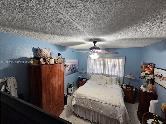 tiled bedroom featuring ceiling fan and a textured ceiling