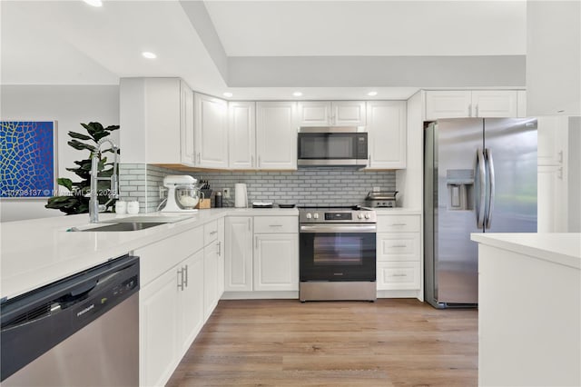 kitchen featuring white cabinetry, light countertops, stainless steel appliances, and a sink