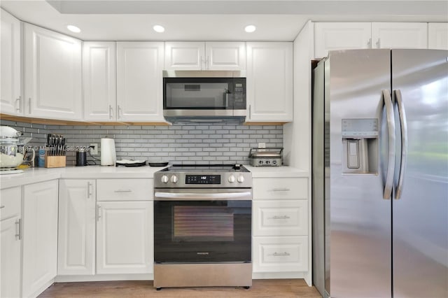 kitchen with white cabinetry, light countertops, stainless steel appliances, and tasteful backsplash