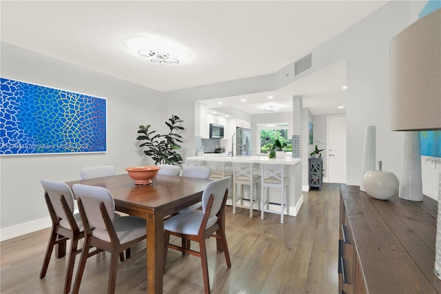 dining area with visible vents, wood finished floors, baseboards, and recessed lighting