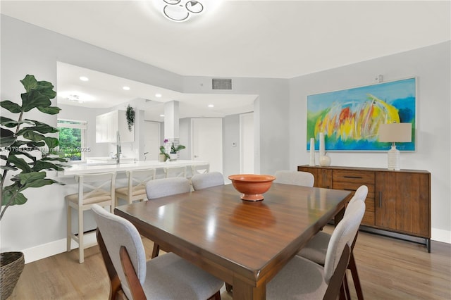 dining room with light wood-type flooring, recessed lighting, baseboards, and visible vents