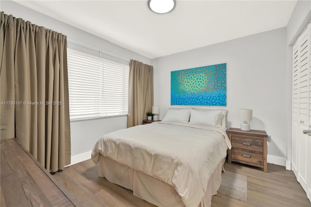 bedroom featuring wood finished floors and baseboards