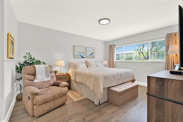 bedroom featuring baseboards and light wood-style flooring