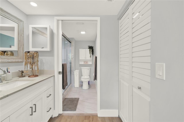 bathroom featuring a stall shower, toilet, and vanity