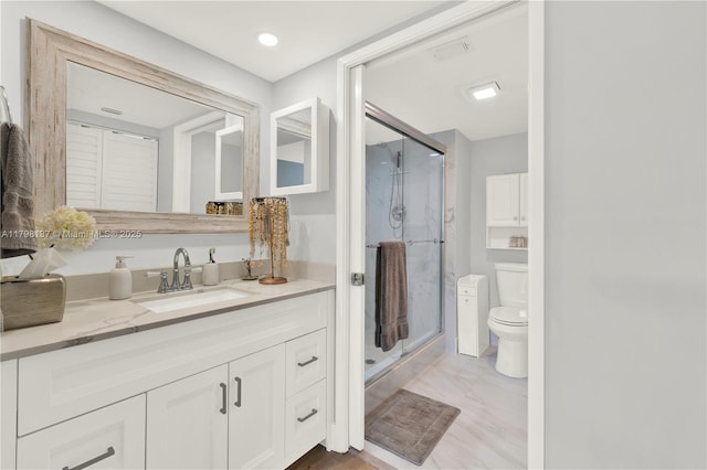 bathroom featuring vanity, toilet, and a stall shower