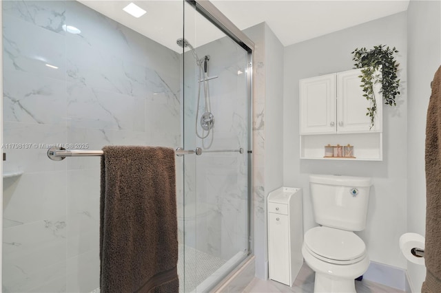 bathroom featuring a marble finish shower and toilet