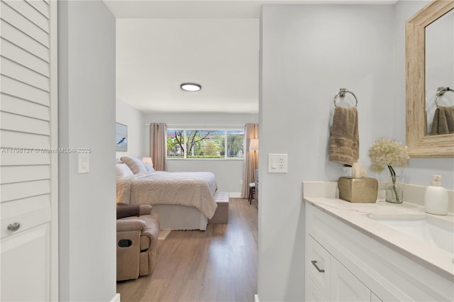 bedroom featuring a sink and light wood-style flooring