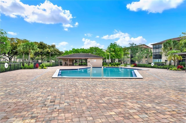 community pool featuring fence and a patio area