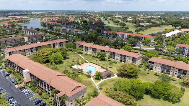 bird's eye view of a large body of water, apartment complex / building, and a pool area