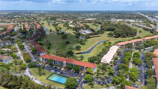 aerial view of property and surrounding area with a nearby body of water and a golf course