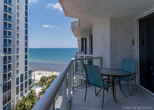 balcony with a water view and a beach view