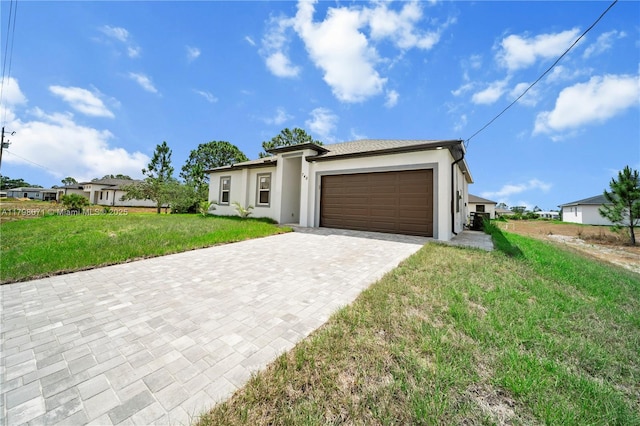 prairie-style home featuring an attached garage, decorative driveway, stucco siding, and a front lawn