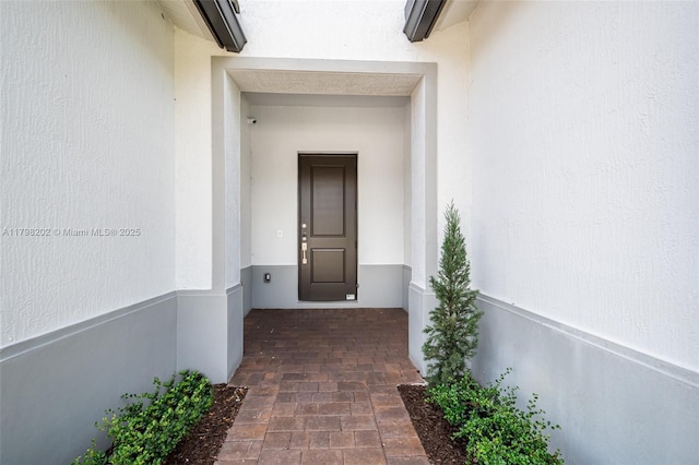 view of exterior entry with stucco siding