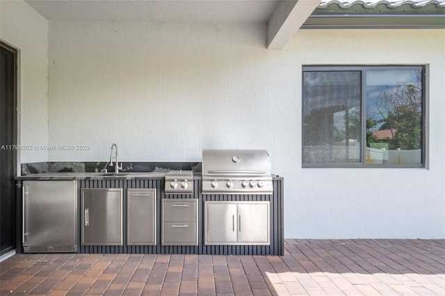 view of patio / terrace featuring an outdoor kitchen, area for grilling, and a sink