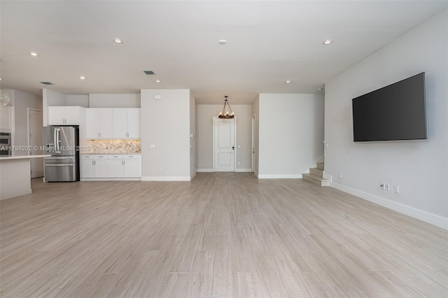 unfurnished living room with recessed lighting, baseboards, visible vents, stairs, and light wood-style floors