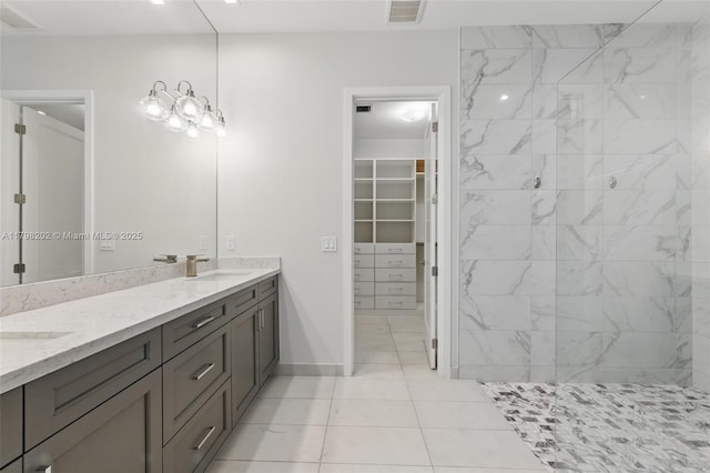 full bath featuring double vanity, visible vents, tile patterned flooring, and a sink