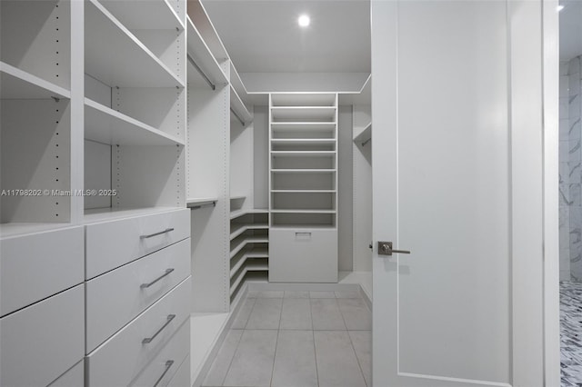 walk in closet with light tile patterned floors